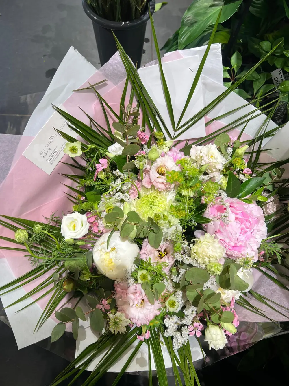 Bouquet de fleurs roses et blanches emballé dans du papier rose
