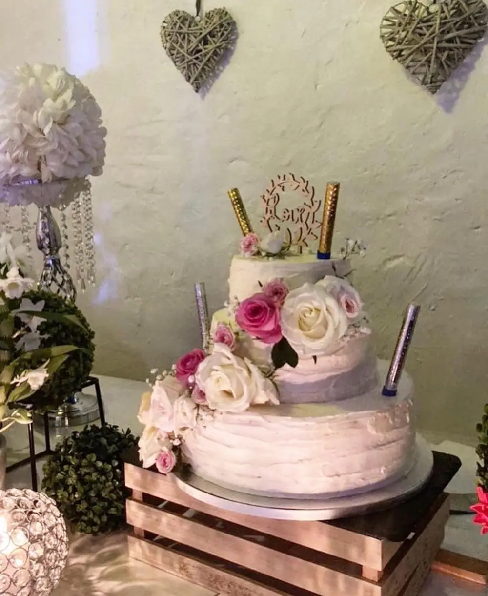 Gâteau de mariage fleuri de roses, présenté lors d'une réception